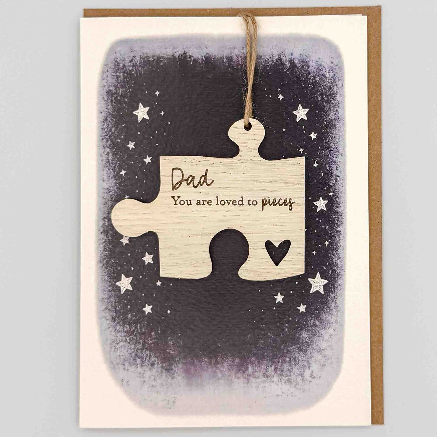 Dad loved to pieces jigsaw keepsake card from Sprinkled with Magic, featuring a removable wooden jigsaw keepsake, small heart detail, starry navy design and recycled kraft envelope.