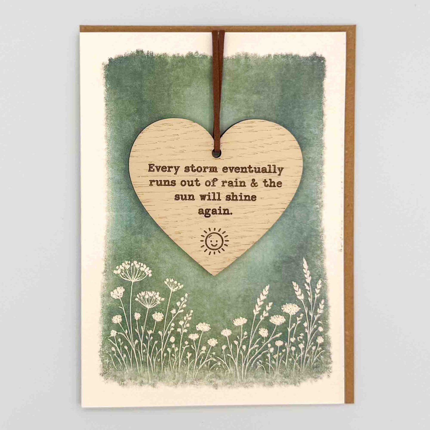 Every storm heart keepsake card from Sprinkled with Magic, featuring a removable wooden heart keepsake, small sun detail, green botanical design and recycled kraft envelope.