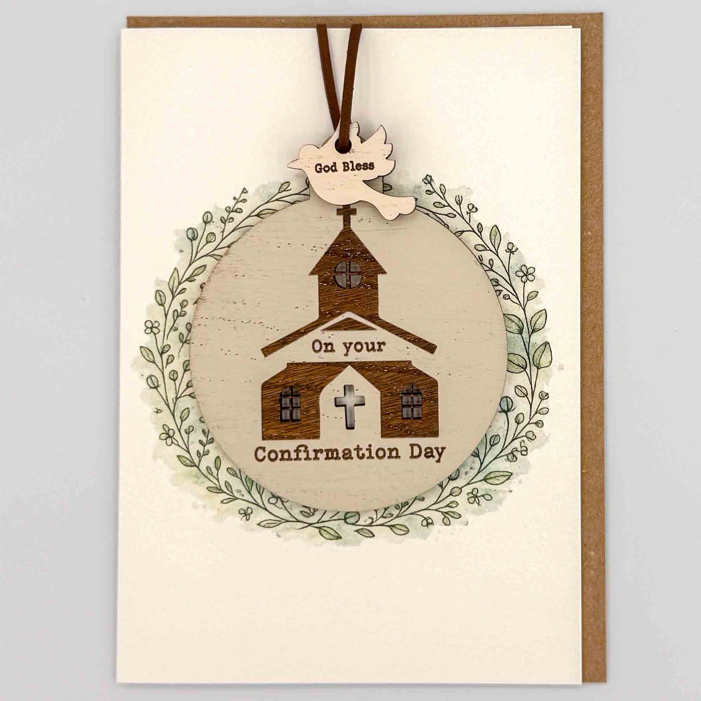Confirmation Day church bauble keepsake card from Sprinkled with Magic, featuring a removable wooden church bauble keepsake, cross detail, leafy wreath design and recycled kraft envelope.