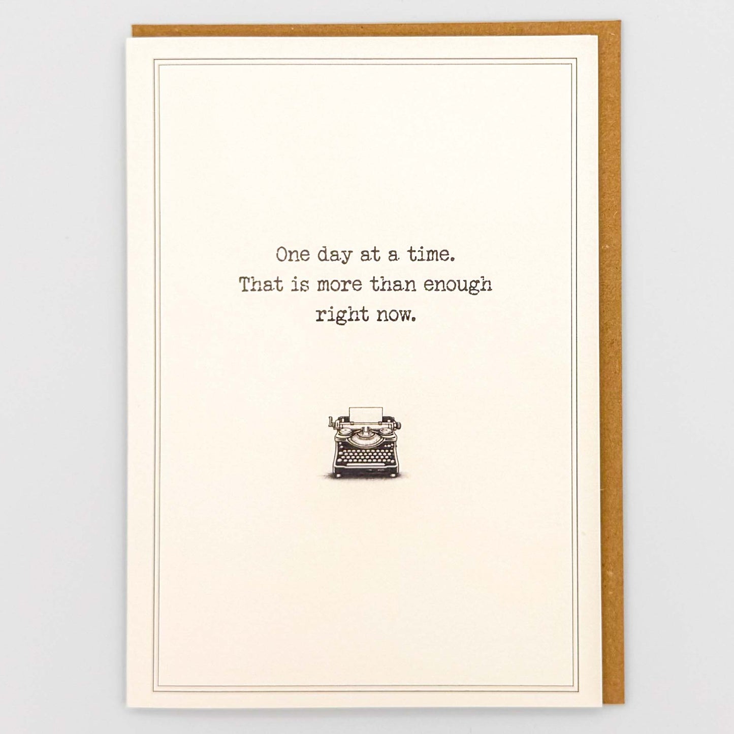 One day at a time typewriter card from Sprinkled with Magic, featuring reassuring wording, a vintage typewriter illustration and recycled kraft envelope.