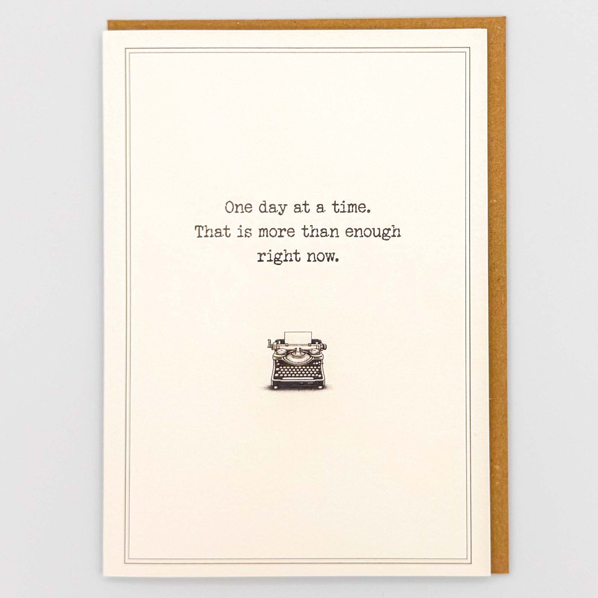 One day at a time typewriter card from Sprinkled with Magic, featuring reassuring wording, a vintage typewriter illustration and recycled kraft envelope.
