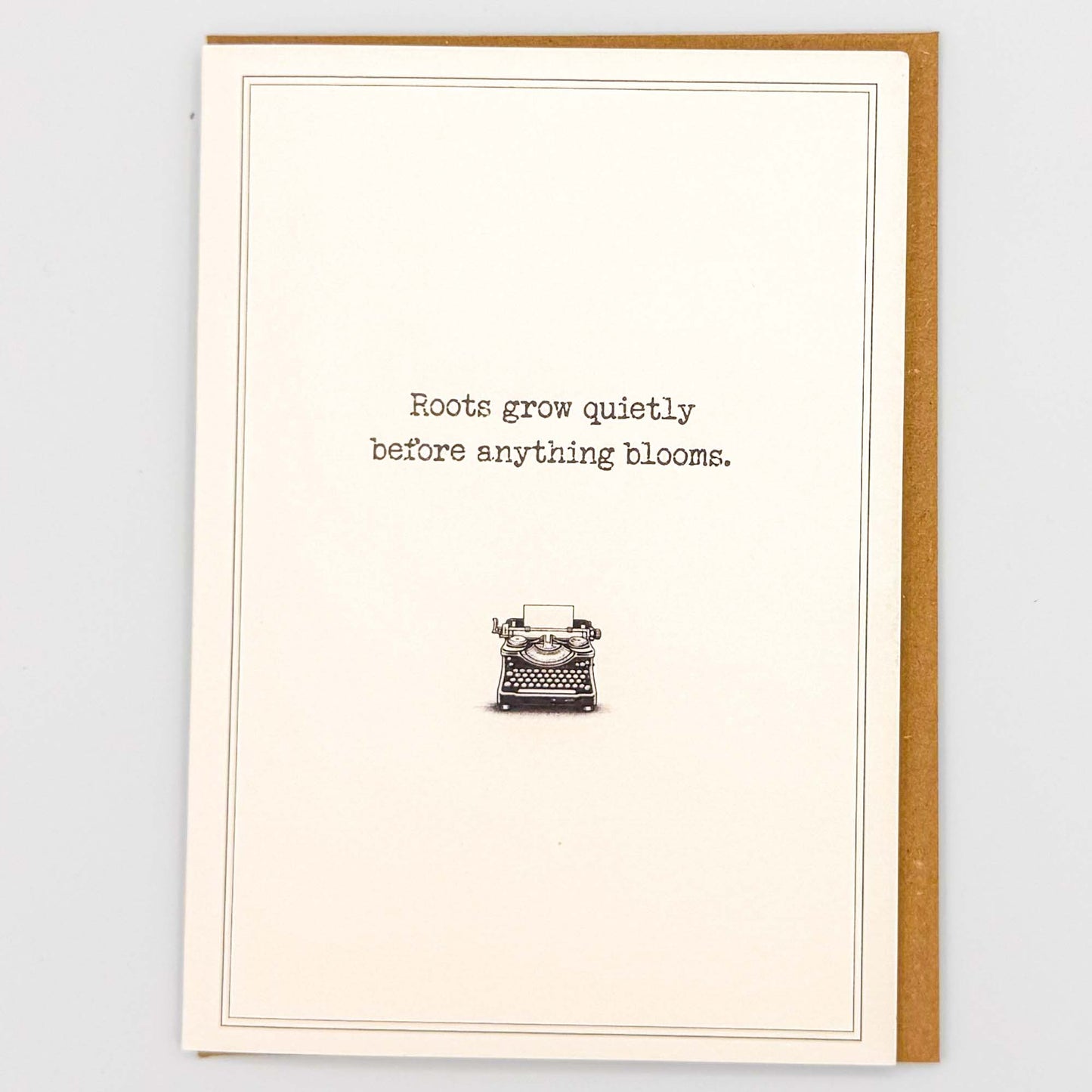 Roots grow quietly typewriter card from Sprinkled with Magic, featuring hopeful wording, a vintage typewriter illustration and recycled kraft envelope.