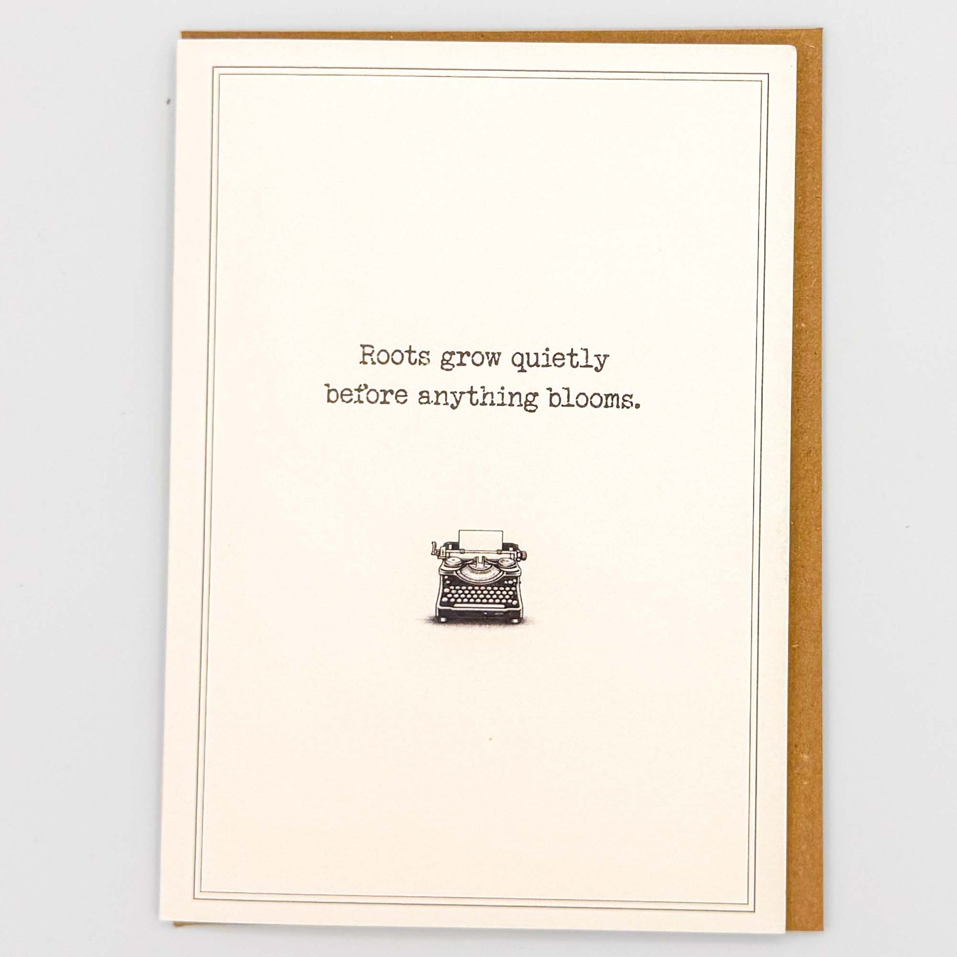 Roots grow quietly typewriter card from Sprinkled with Magic, featuring hopeful wording, a vintage typewriter illustration and recycled kraft envelope.