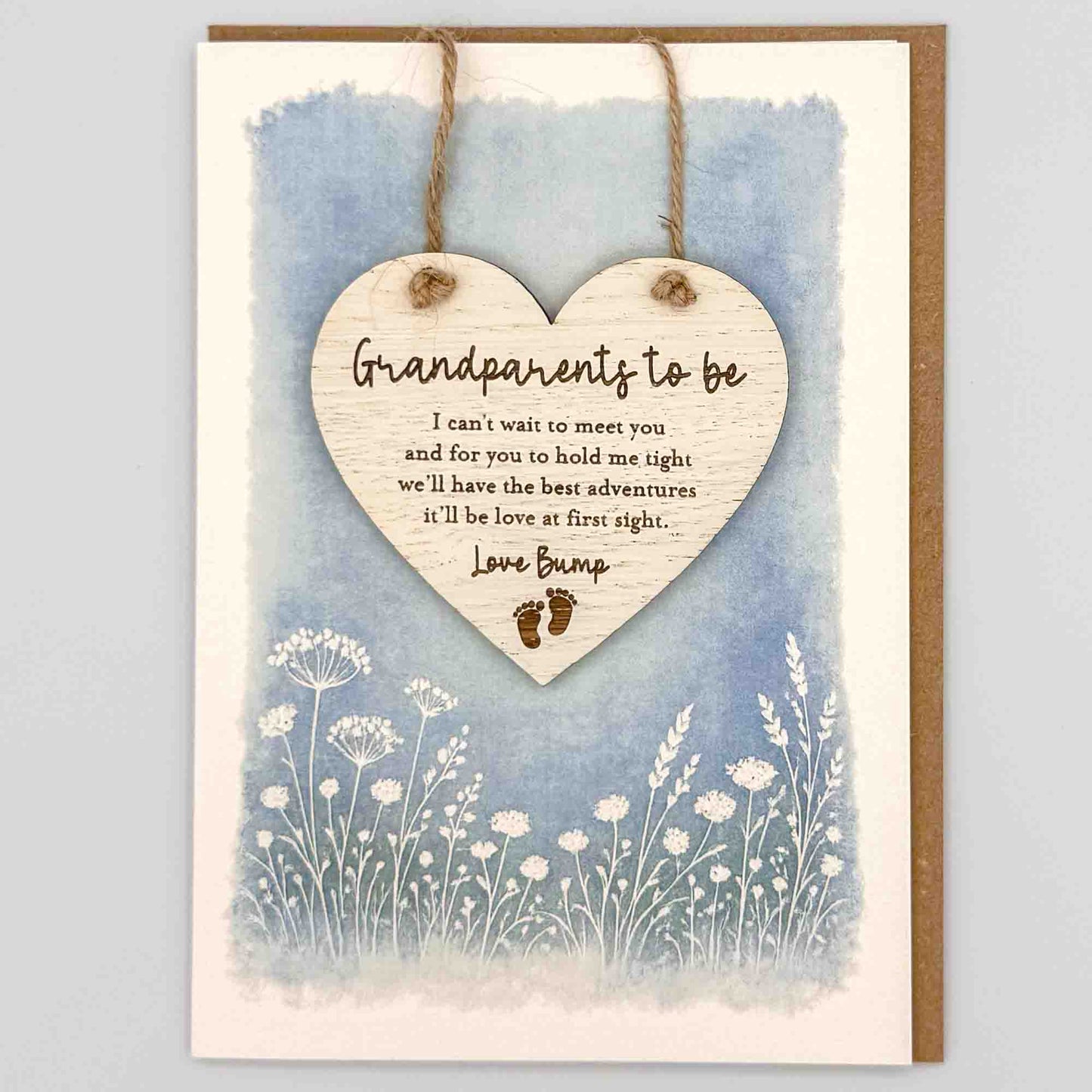 Grandparents to be love bump heart keepsake card from Sprinkled with Magic, featuring a removable wooden heart keepsake, baby feet detail, blue botanical design and recycled kraft envelope.