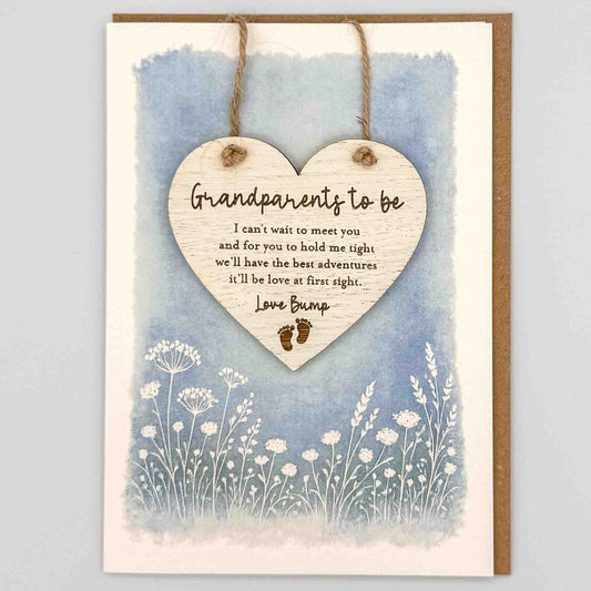 Grandparents to be love bump heart keepsake card from Sprinkled with Magic, featuring a removable wooden heart keepsake, baby feet detail, blue botanical design and recycled kraft envelope.