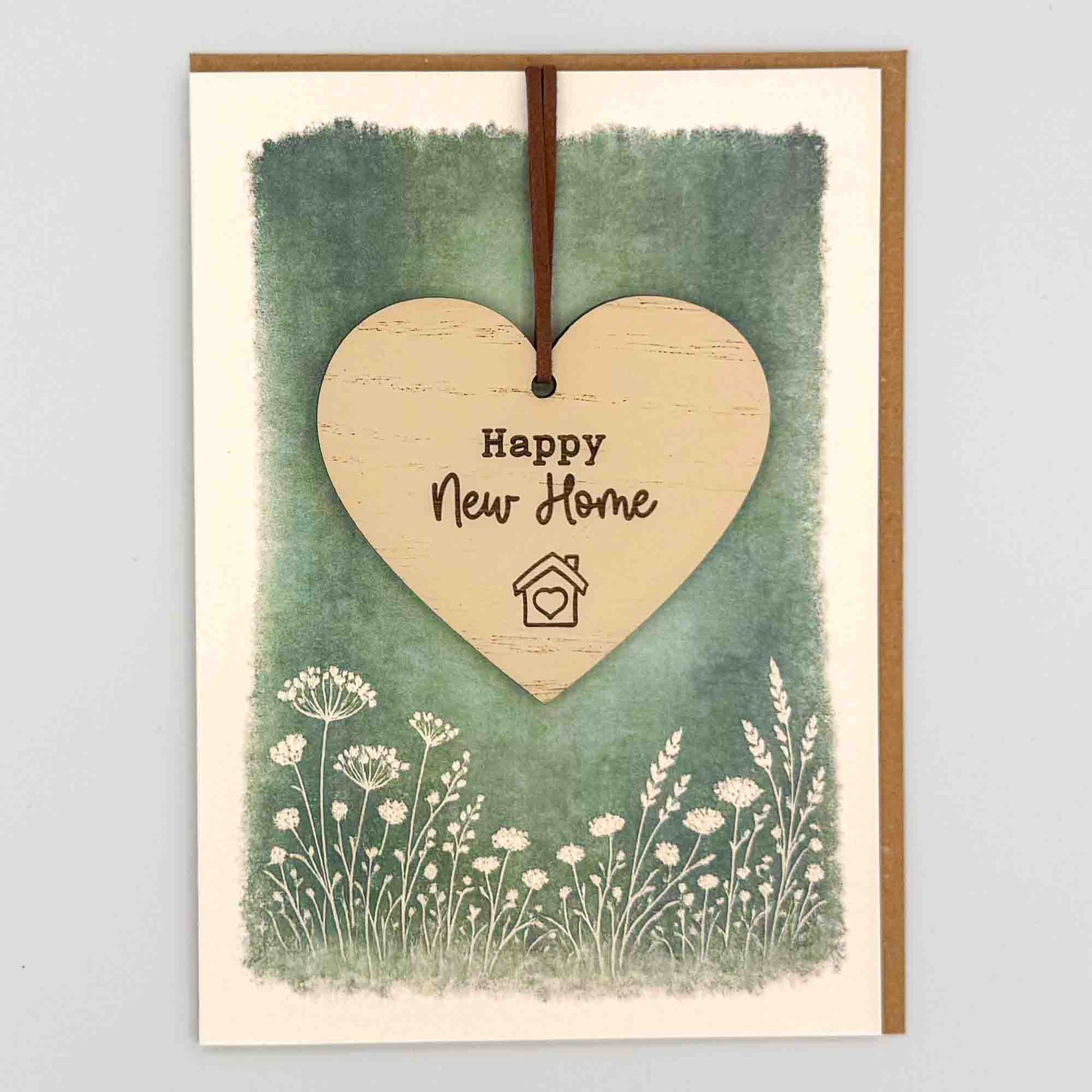 Happy new home heart keepsake card from Sprinkled with Magic, featuring a removable wooden heart keepsake, green botanical design and recycled kraft envelope.