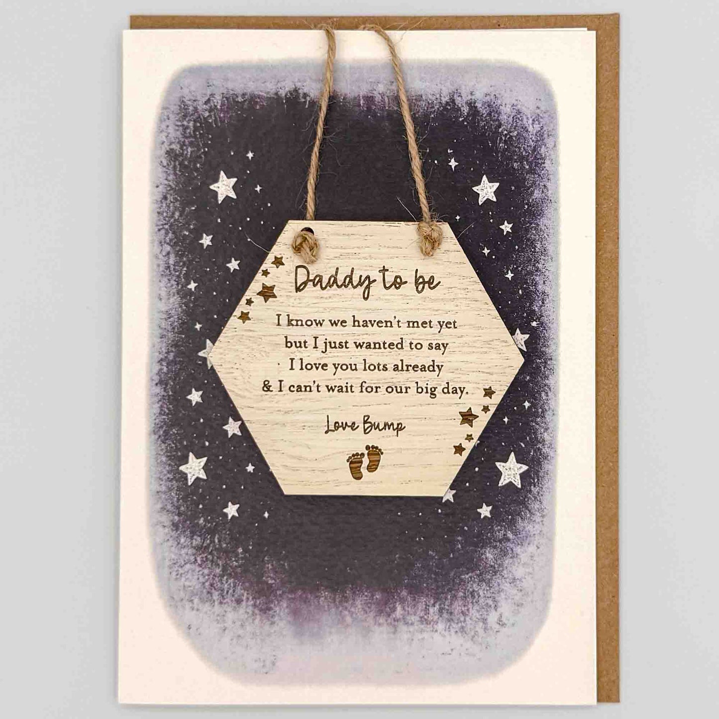 Daddy to be love bump hexagon keepsake card from Sprinkled with Magic, featuring a removable wooden hexagon keepsake, baby feet and star details, starry navy design and recycled kraft envelope.