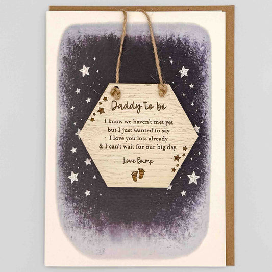 Daddy to be love bump hexagon keepsake card from Sprinkled with Magic, featuring a removable wooden hexagon keepsake, baby feet and star details, starry navy design and recycled kraft envelope.