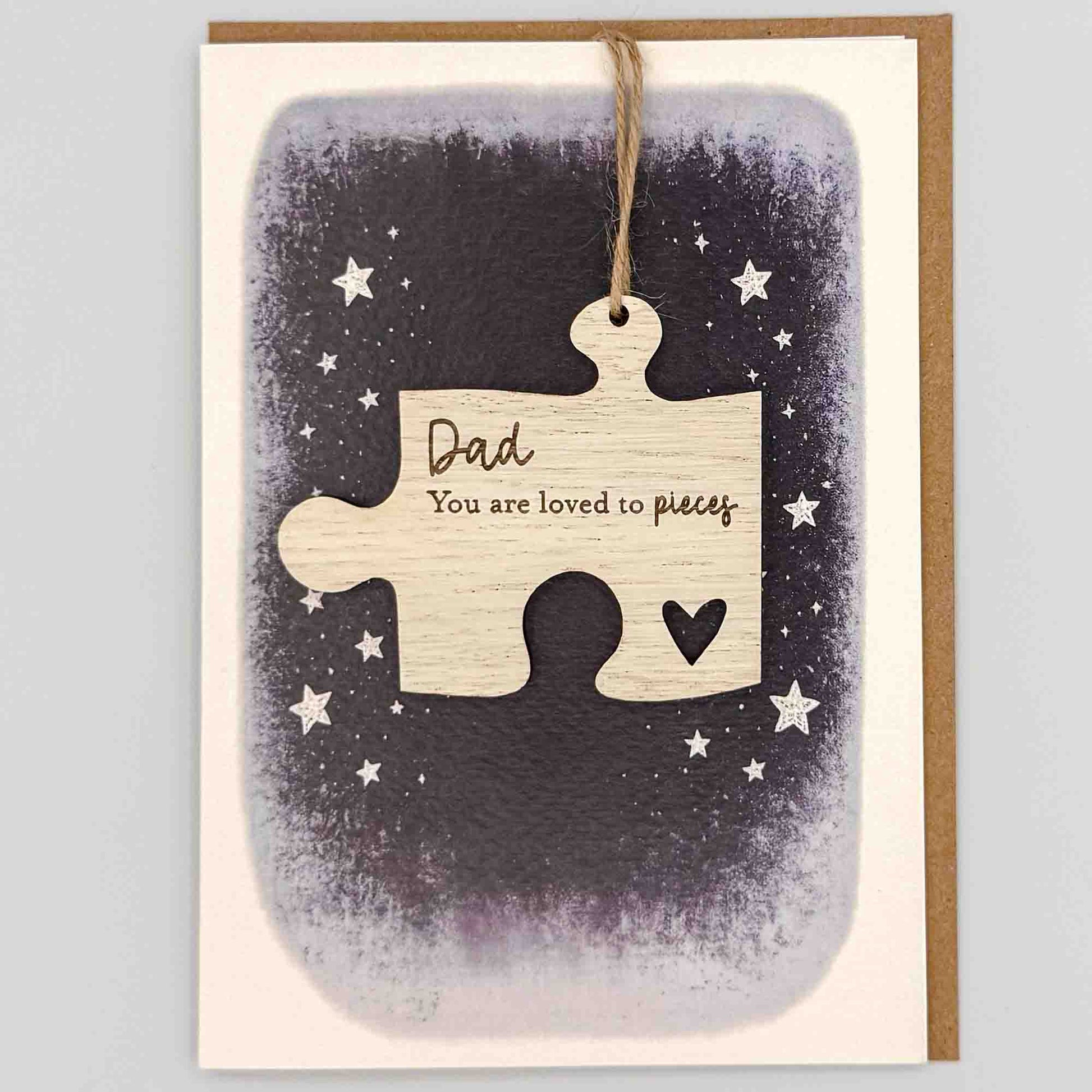 Dad loved to pieces jigsaw keepsake card from Sprinkled with Magic, featuring a removable wooden jigsaw keepsake, small heart detail, starry navy design and recycled kraft envelope.