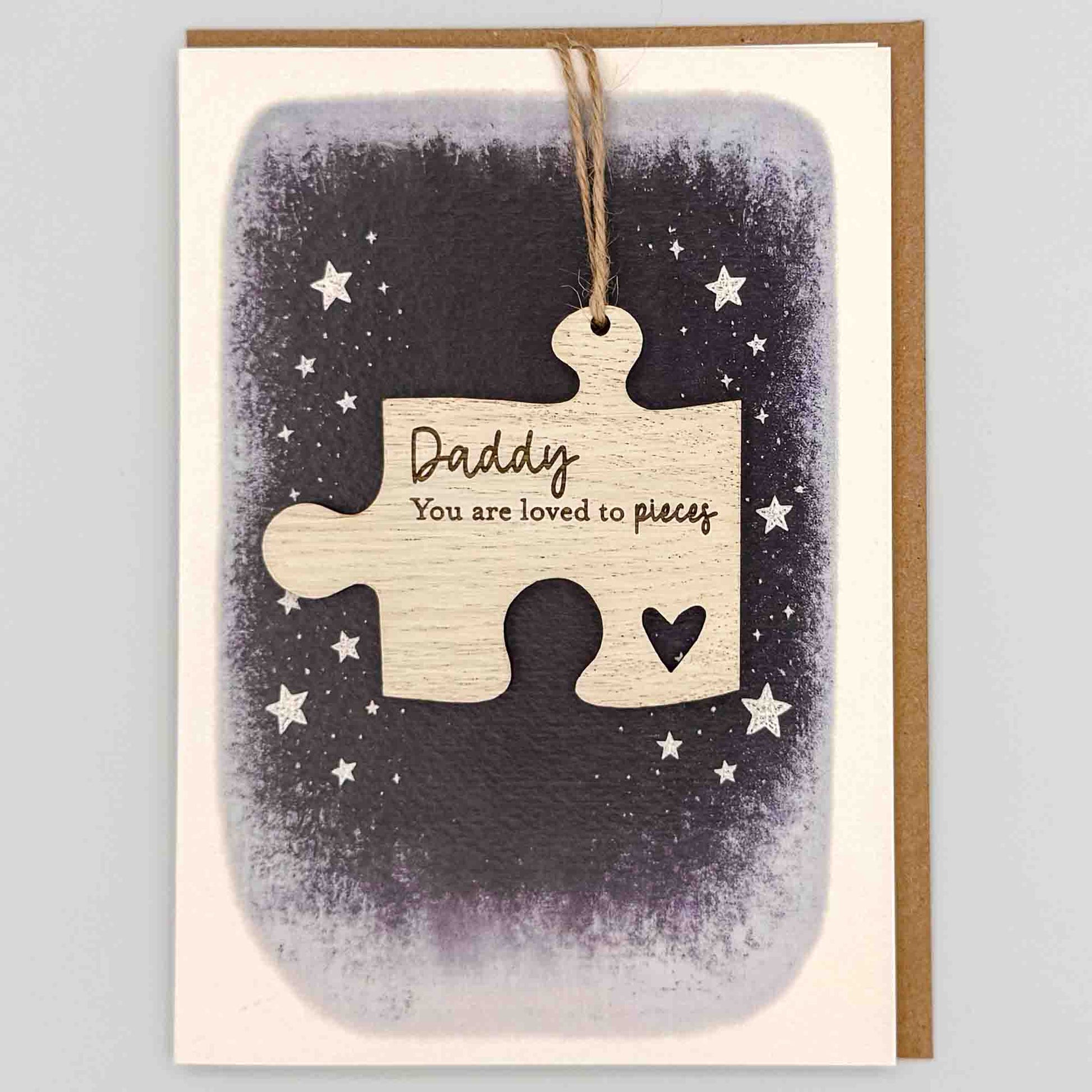 Dad loved to pieces jigsaw keepsake card from Sprinkled with Magic, featuring a removable wooden jigsaw keepsake, small heart detail, starry navy design and recycled kraft envelope.