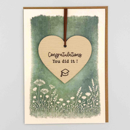 Congratulations graduation cap heart keepsake card from Sprinkled with Magic, featuring a removable wooden heart keepsake, graduation cap detail, green botanical design and recycled kraft envelope.