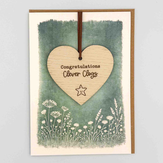Congratulations clever clogs star heart keepsake card from Sprinkled with Magic, featuring a removable wooden heart keepsake, small star detail, green botanical design and recycled kraft envelope.
