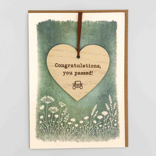 Congratulations you passed car heart keepsake card from Sprinkled with Magic, featuring a removable wooden heart keepsake, small car detail, green botanical design and recycled kraft envelope.