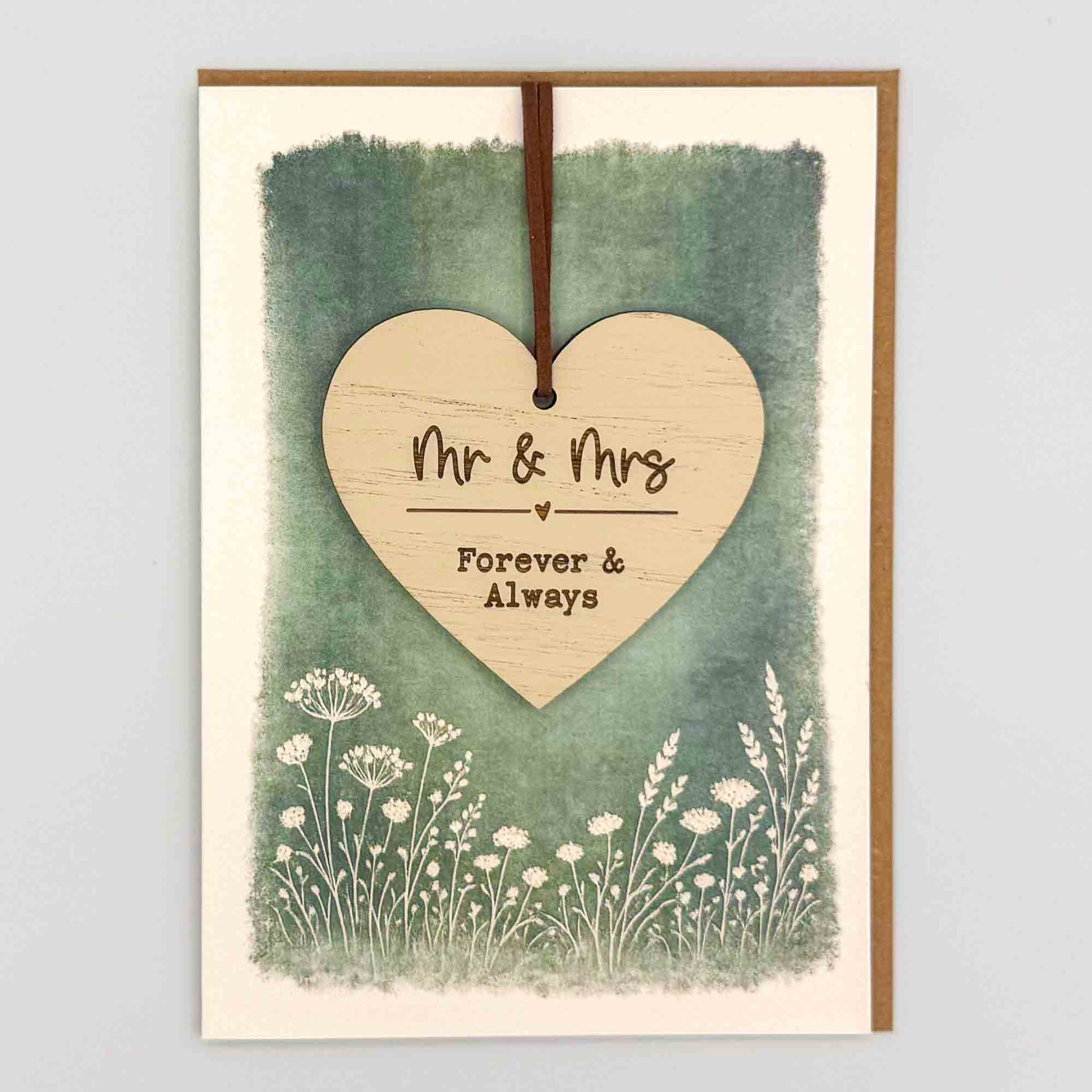Mr and Mrs heart keepsake card from Sprinkled with Magic, featuring a removable wooden wedding heart keepsake, green botanical design and recycled kraft envelope.