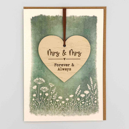 Mrs and Mrs heart keepsake card from Sprinkled with Magic, featuring a removable wooden wedding heart keepsake, green botanical design and recycled kraft envelope.