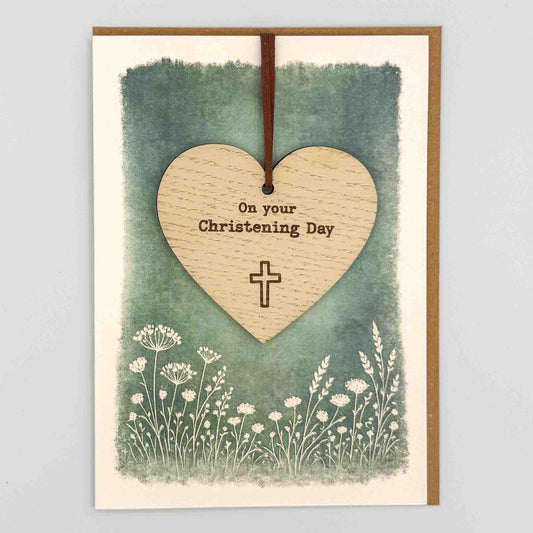 Christening Day heart keepsake card from Sprinkled with Magic, featuring a removable wooden heart keepsake, cross detail, green botanical design and recycled kraft envelope.