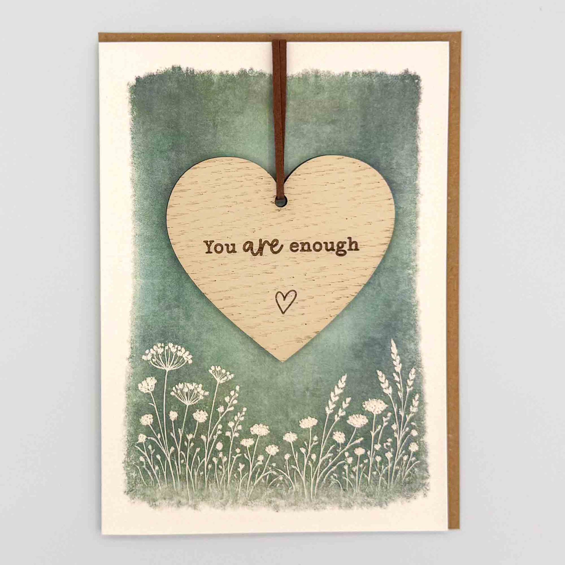 You are enough heart keepsake card from Sprinkled with Magic, featuring a removable wooden heart keepsake, green botanical design and recycled kraft envelope.