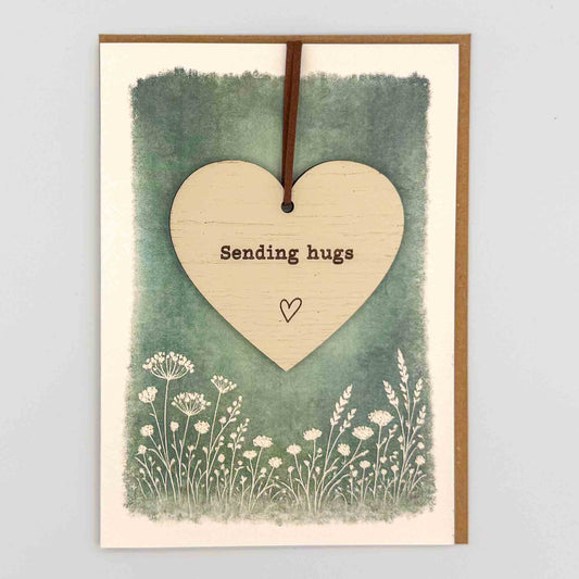 Sending hugs heart keepsake card from Sprinkled with Magic, featuring a removable wooden heart keepsake, green botanical design and recycled kraft envelope.