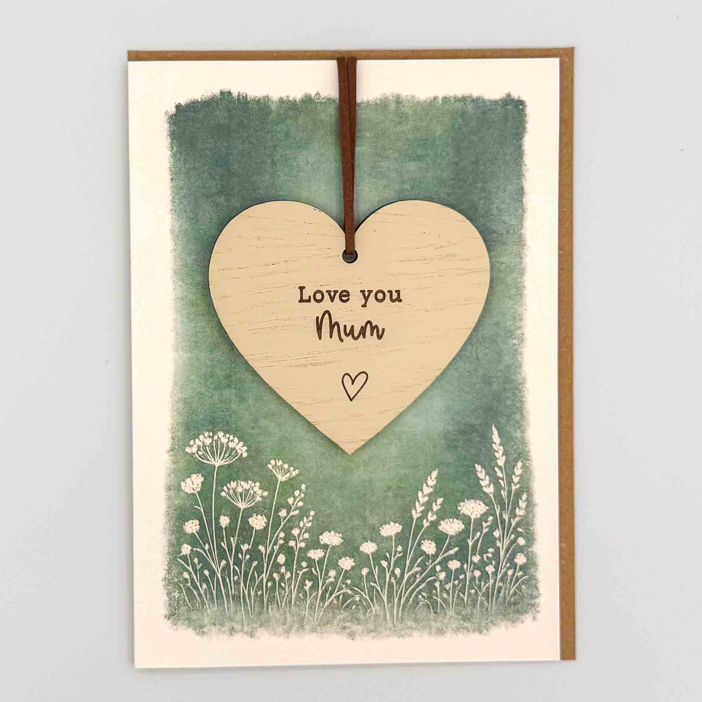 Love you Mum heart keepsake card from Sprinkled with Magic, featuring a removable wooden heart keepsake, green botanical design and recycled kraft envelope.