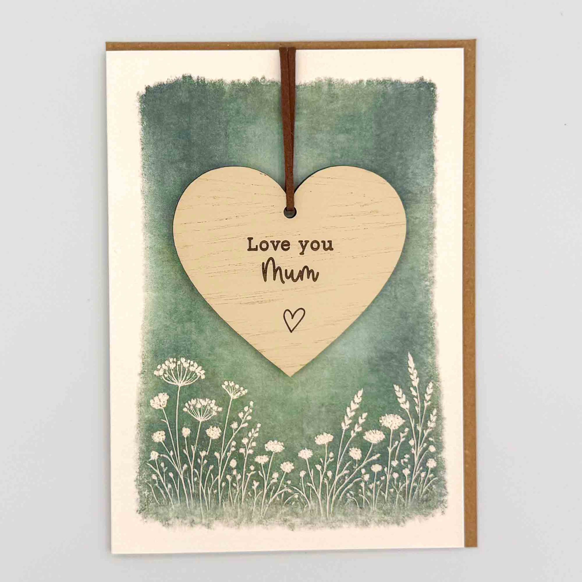 Love you Mum heart keepsake card from Sprinkled with Magic, featuring a removable wooden heart keepsake, green botanical design and recycled kraft envelope.