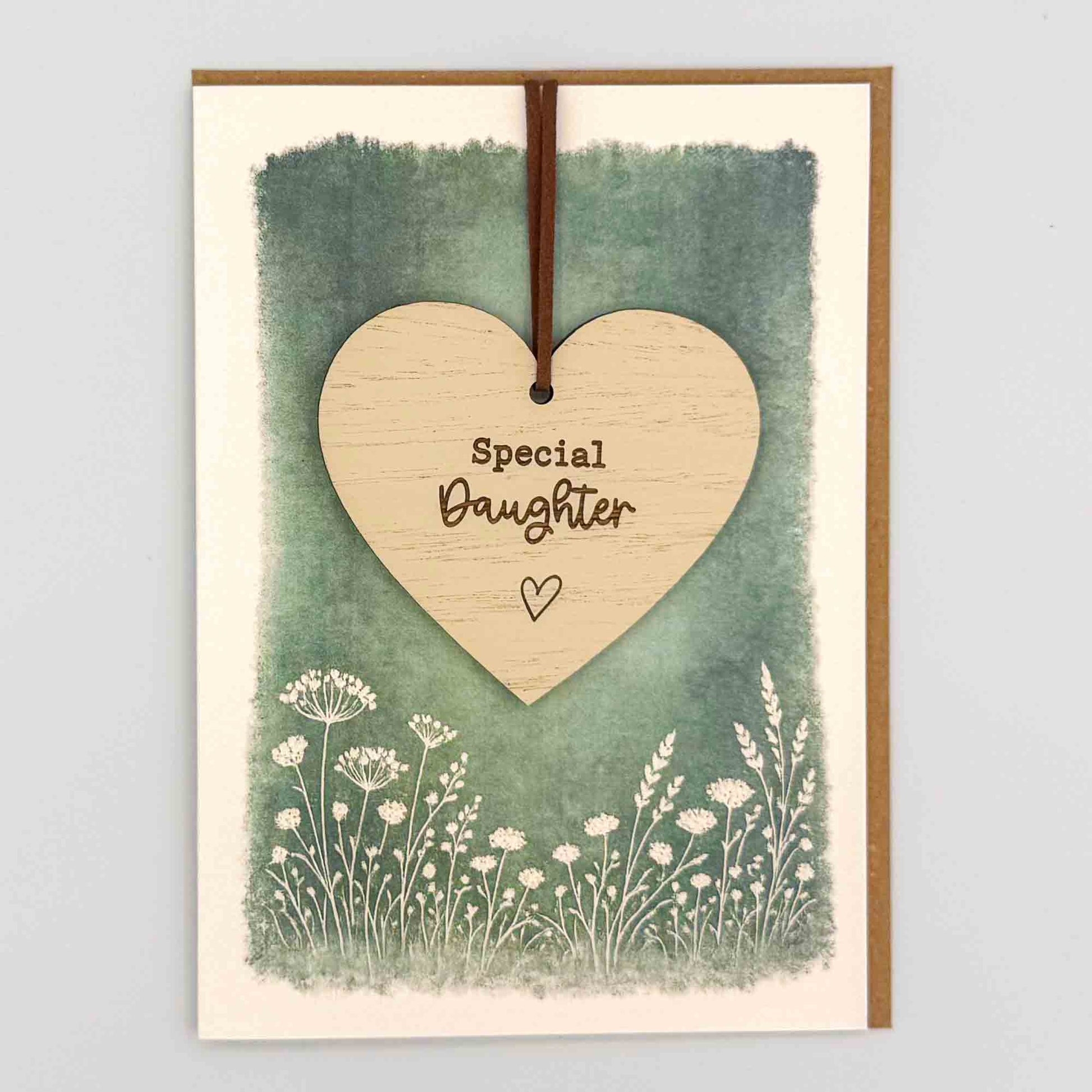 Special daughter heart keepsake card from Sprinkled with Magic, featuring a removable wooden heart keepsake, green botanical design and recycled kraft envelope.