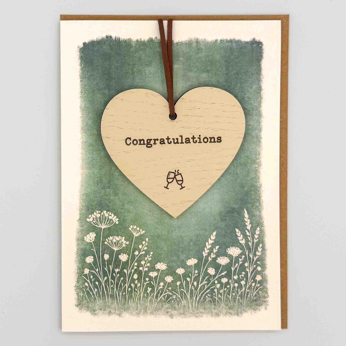 Congratulations heart keepsake card from Sprinkled with Magic, featuring a removable wooden heart keepsake, small celebratory detail, green botanical design and recycled kraft envelope.