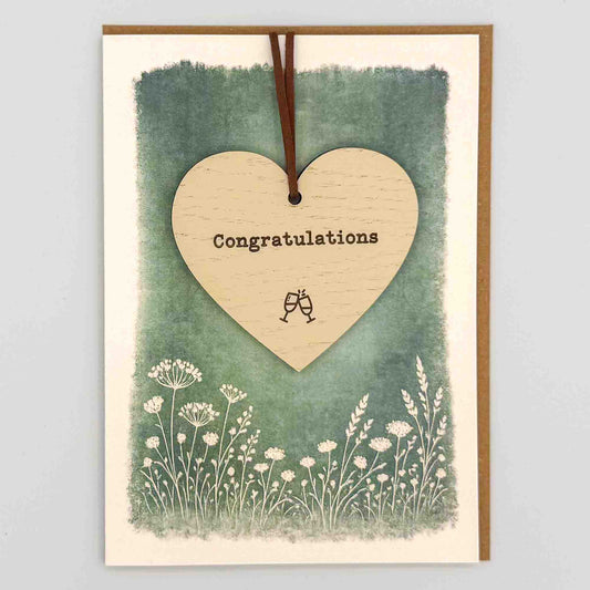 Congratulations heart keepsake card from Sprinkled with Magic, featuring a removable wooden heart keepsake, small celebratory detail, green botanical design and recycled kraft envelope.