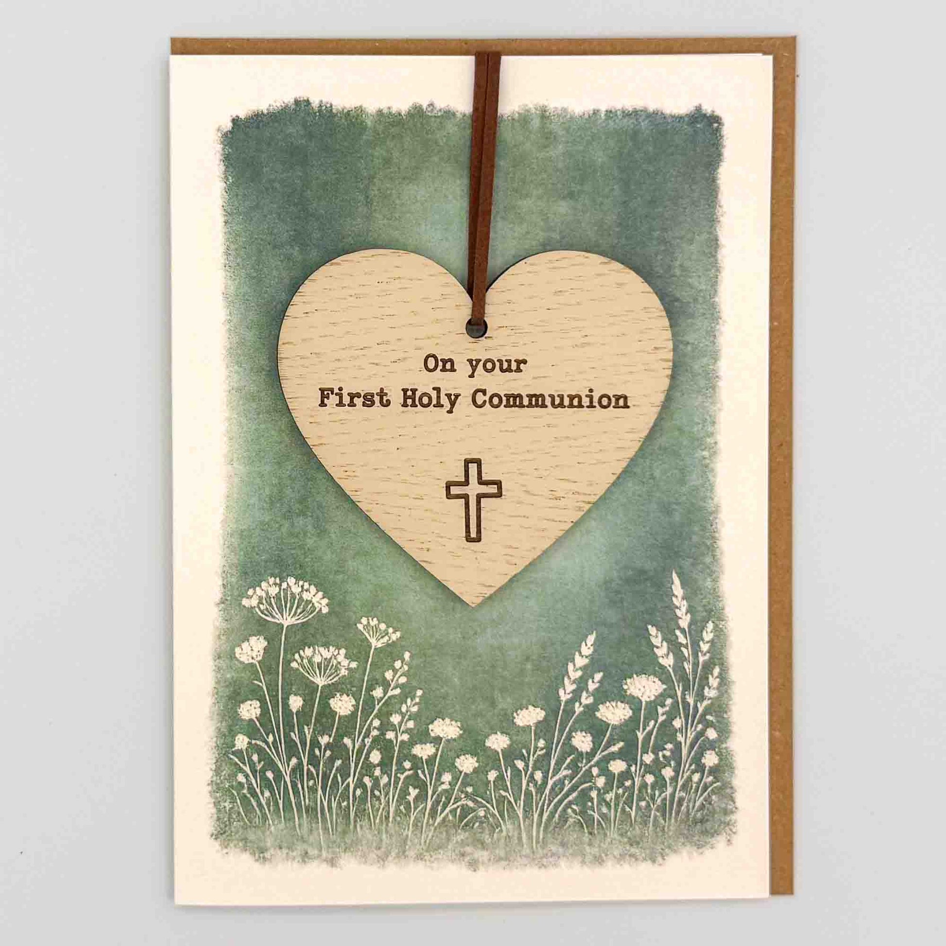First Holy Communion heart keepsake card from Sprinkled with Magic, featuring a removable wooden heart keepsake, cross detail, green botanical design and recycled kraft envelope.