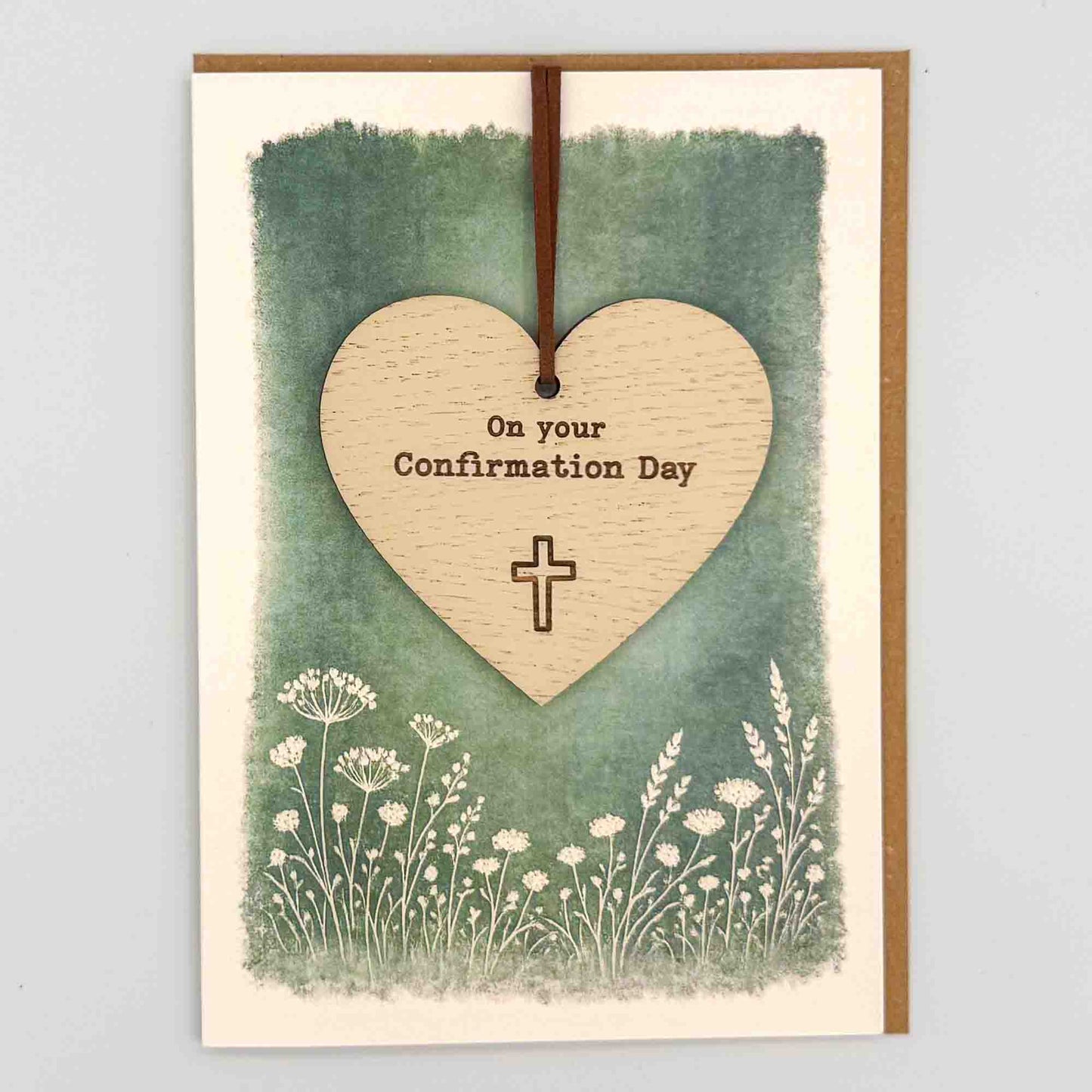 Confirmation Day heart keepsake card from Sprinkled with Magic, featuring a removable wooden heart keepsake, cross detail, green botanical design and recycled kraft envelope.