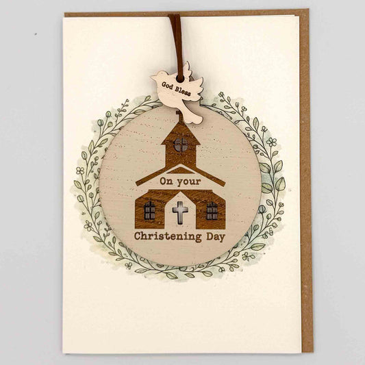 Christening Day church bauble keepsake card from Sprinkled with Magic, featuring a removable wooden church bauble keepsake, cross detail, leafy wreath design and recycled kraft envelope.