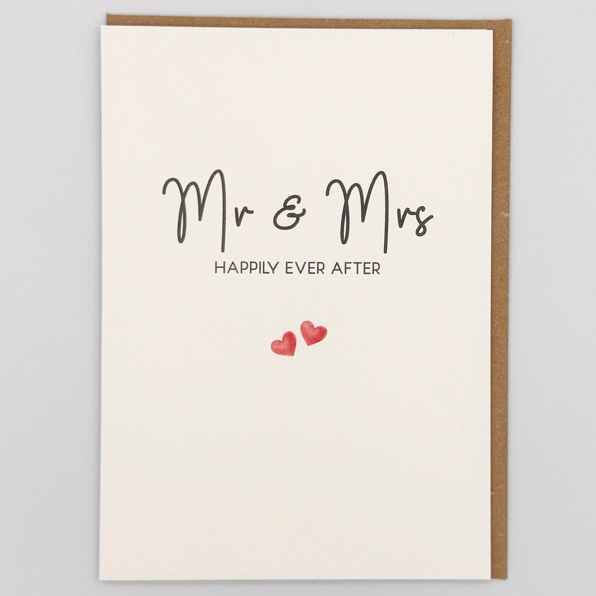 Mr and Mrs wedding card from Sprinkled with Magic, featuring handwritten-style happily ever after wording, two small pink hearts and recycled kraft envelope.
