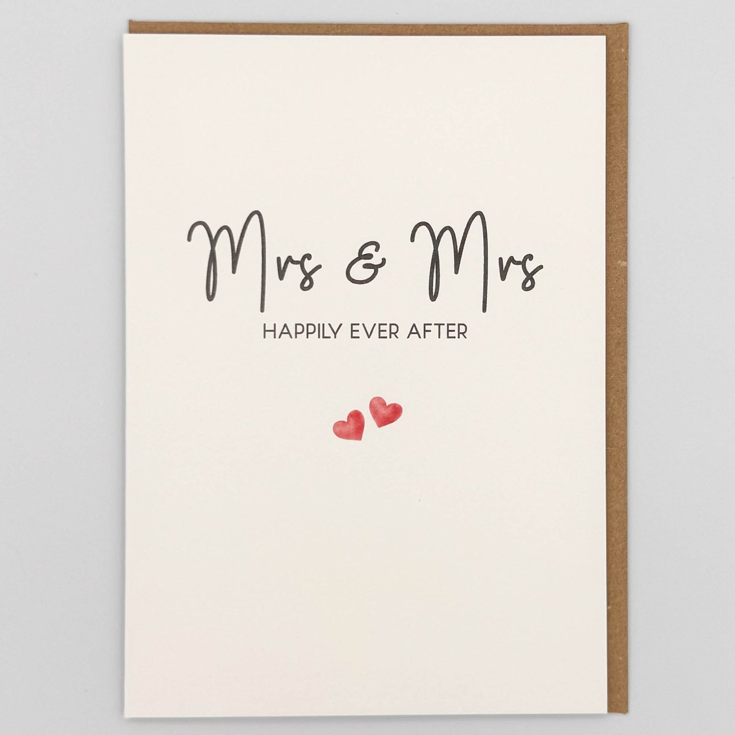 Mrs and Mrs wedding card from Sprinkled with Magic, featuring handwritten-style happily ever after wording, two small pink hearts and recycled kraft envelope.