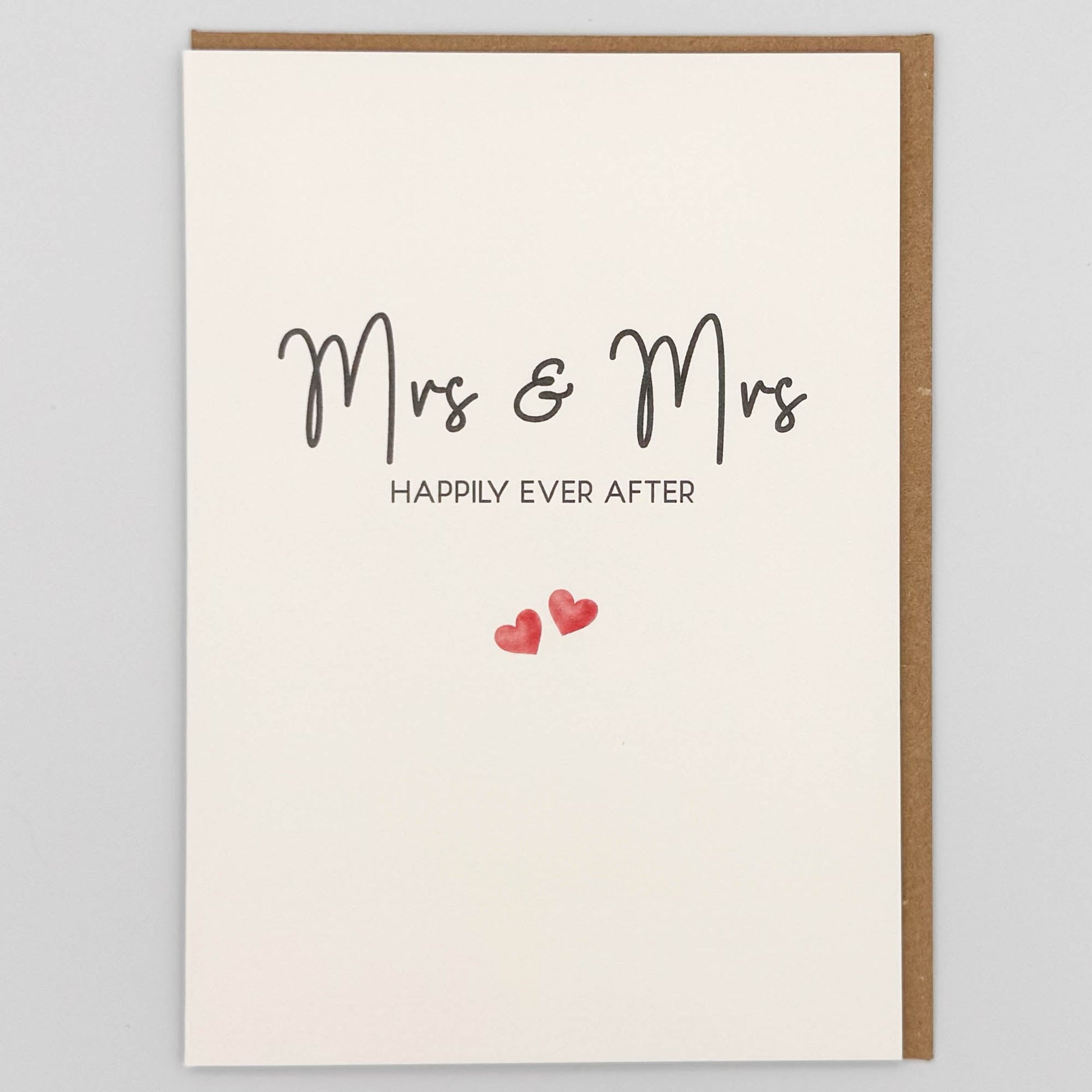 Mrs and Mrs wedding card from Sprinkled with Magic, featuring handwritten-style happily ever after wording, two small pink hearts and recycled kraft envelope.