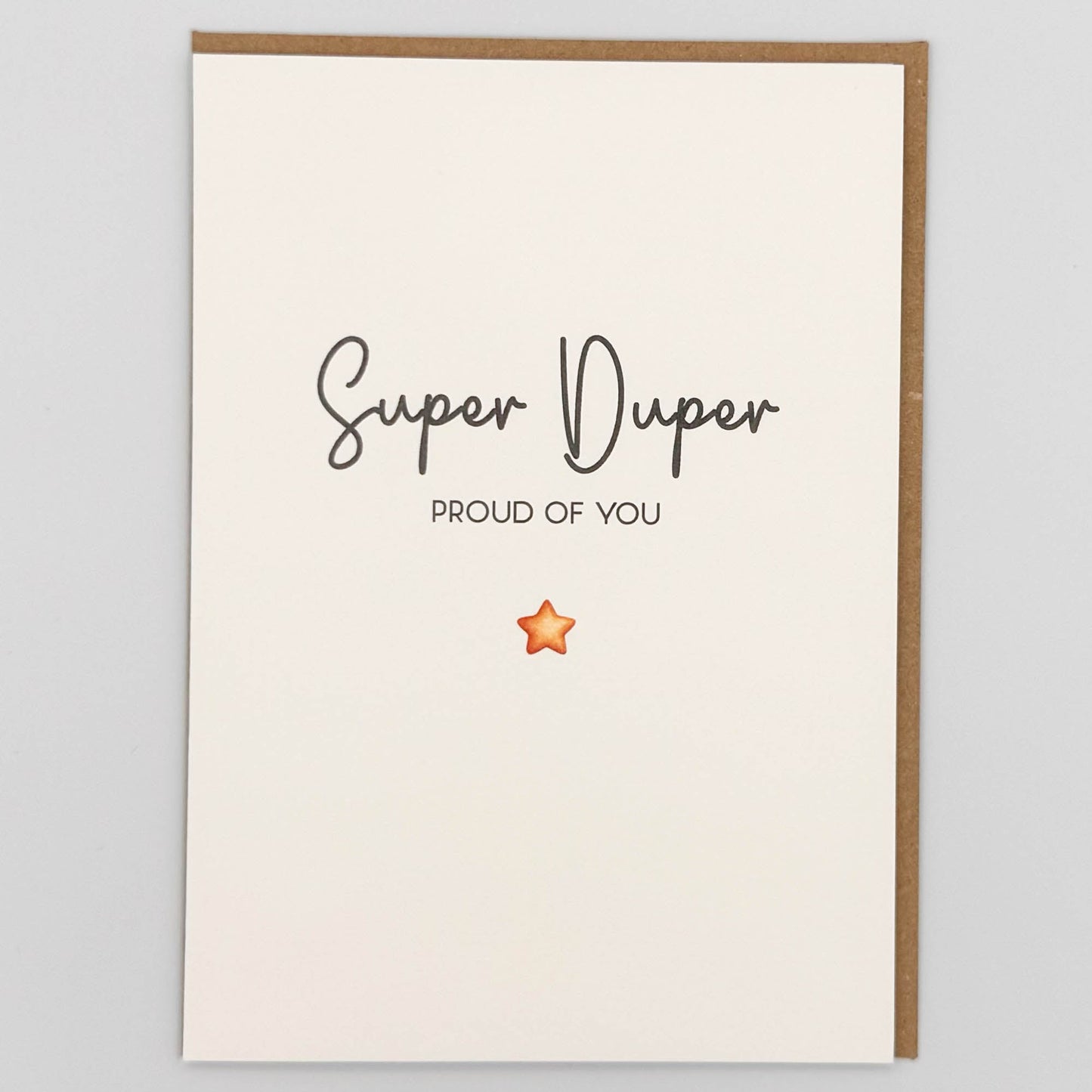 Super duper proud of you card from Sprinkled with Magic, featuring handwritten-style wording, a small orange star and recycled kraft envelope.