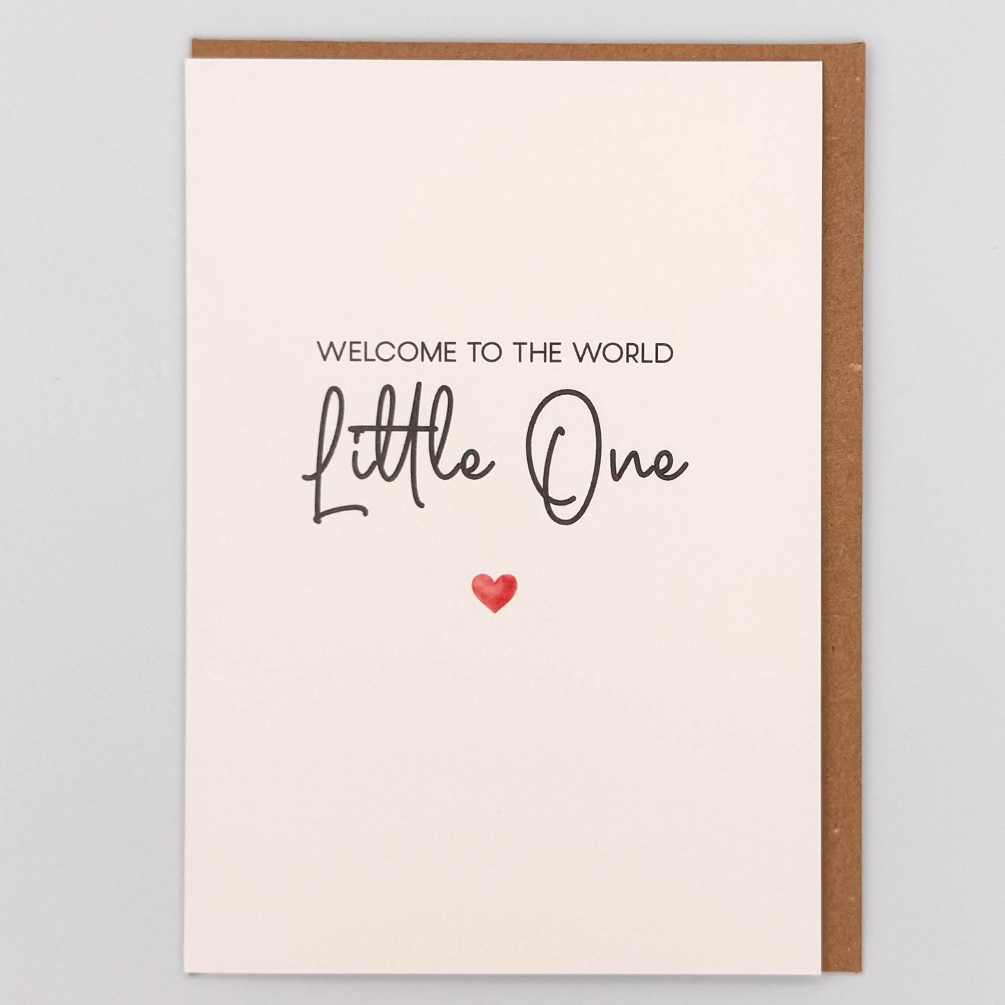 Welcome little one new baby card from Sprinkled with Magic, featuring handwritten-style wording, a small red heart and recycled kraft envelope.