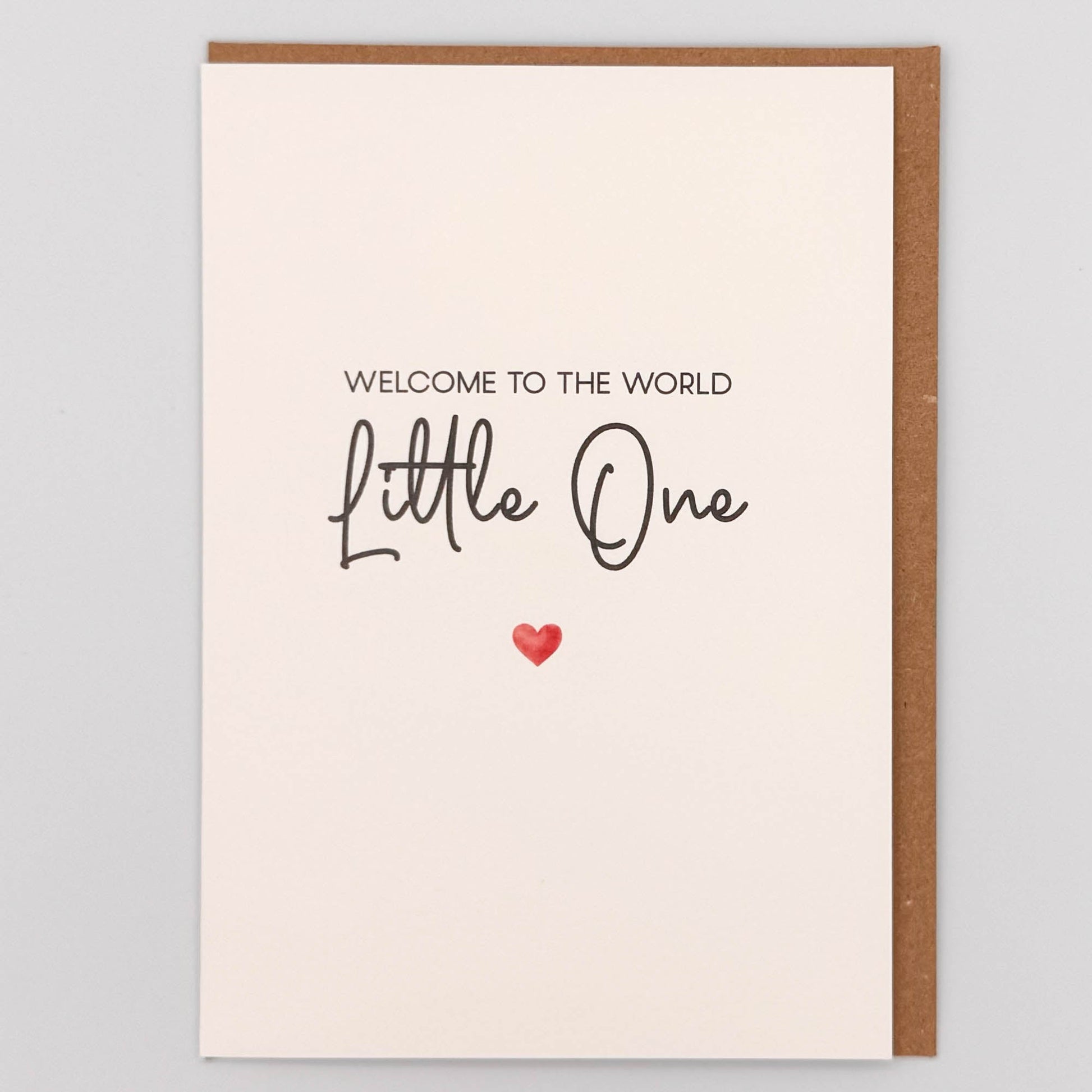 Welcome little one new baby card from Sprinkled with Magic, featuring handwritten-style wording, a small red heart and recycled kraft envelope.