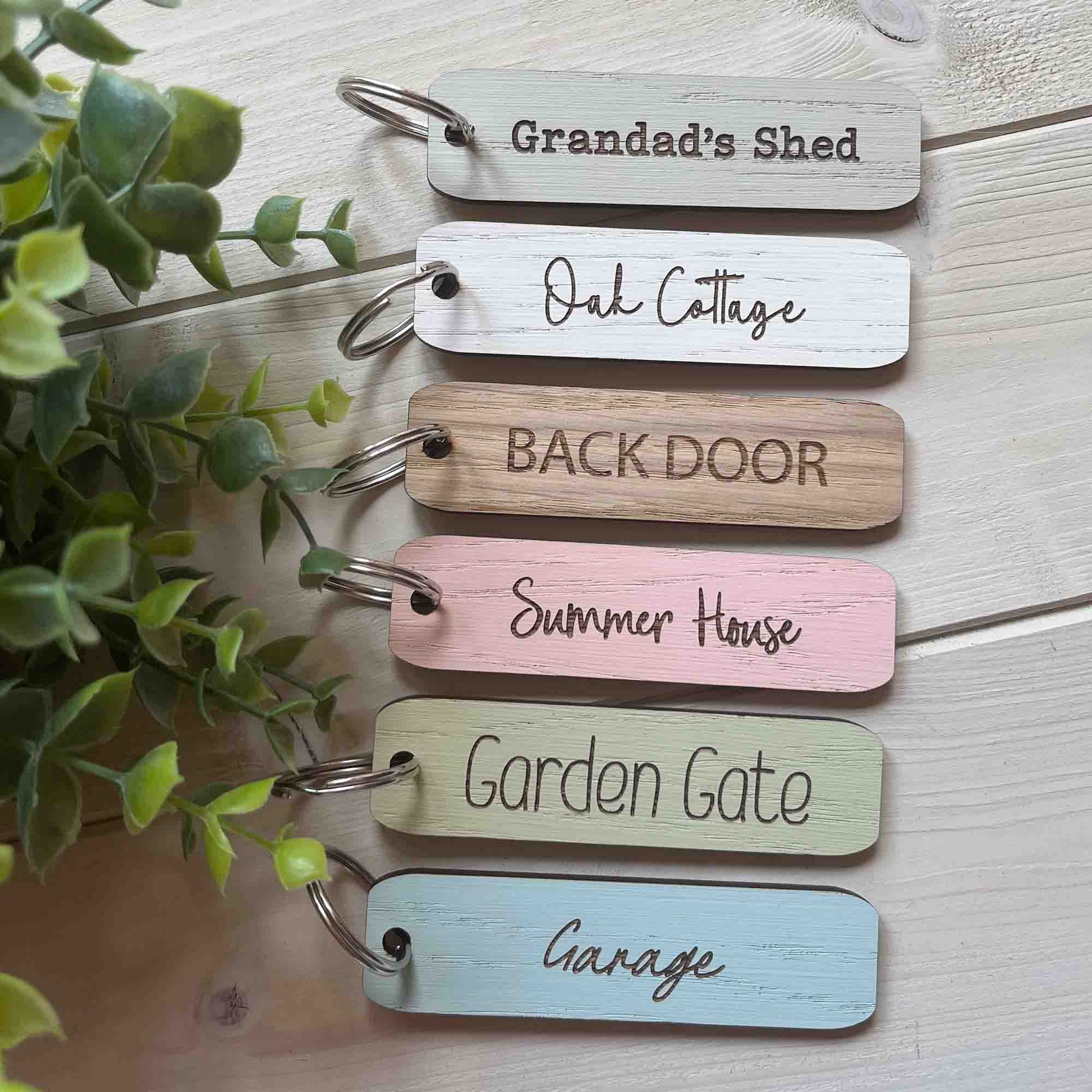Set of wooden keychains with engraved text on a light wooden key fob