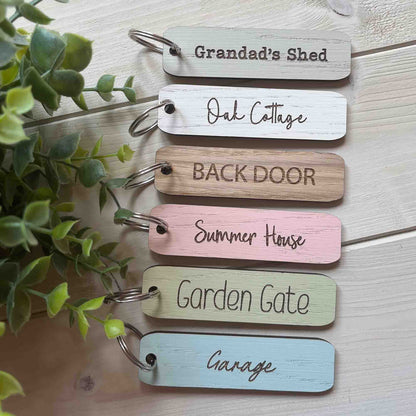 Set of wooden keychains with engraved text on a light wooden key fob