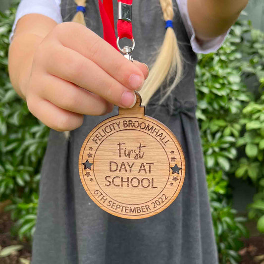 FIRST DAY AT SCHOOL MEDAL. WOODEN MEDAL WITH CUT OUT STARS